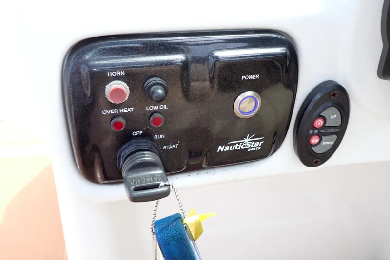 Slide: The Image of Control panel of 2019 NauticStar 243DC Sport Deck boat with ignition and warning indicators. - 14