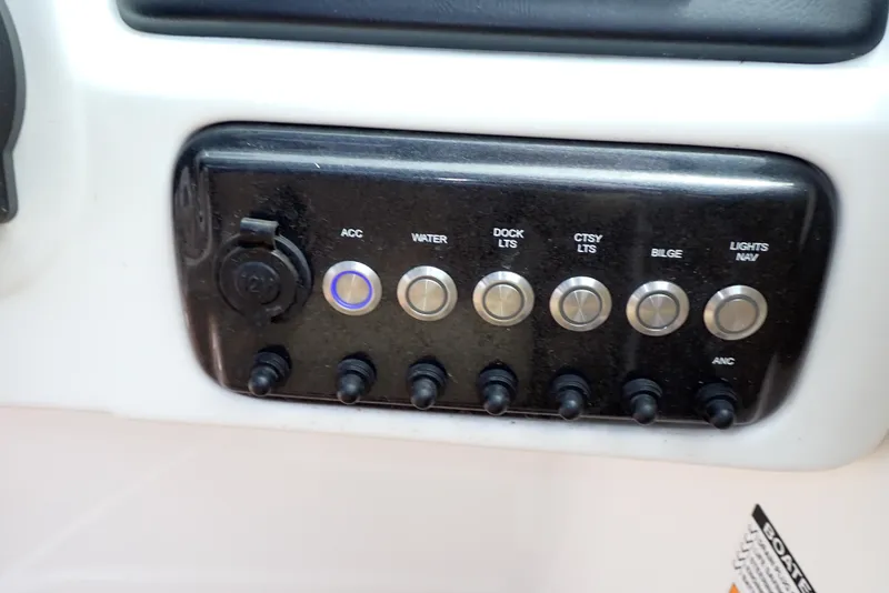 Slide: The Image of Control panel of 2019 NauticStar 243DC Sport Deck boat with labeled switches. - 15