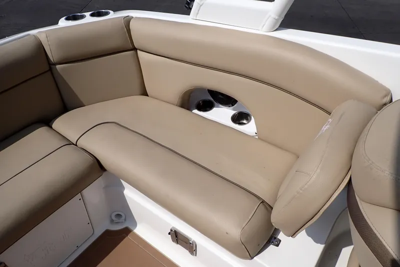 Slide: The Image of 2019 NauticStar 243DC Sport Deck boat with beige cushioned seating. - 19