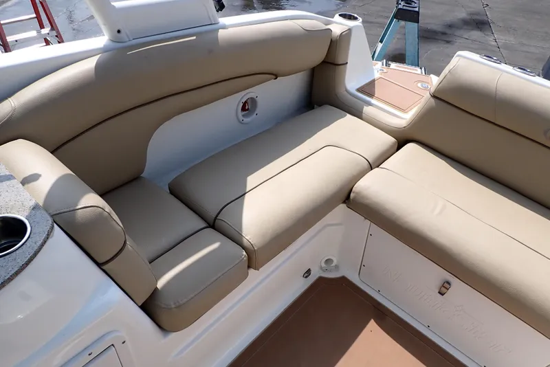 Slide: The Image of 2019 NauticStar 243DC Sport Deck boat with beige seating and cup holders. - 20