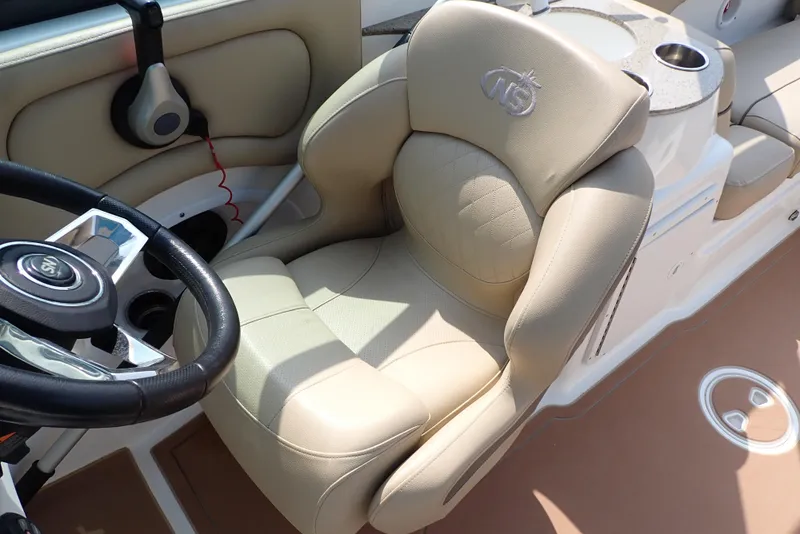Slide: The Image of 2019 NauticStar 243DC Sport Deck boat with beige captain's chair and steering wheel. - 21