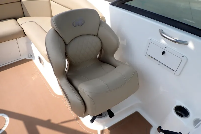 Slide: The Image of 2019 NauticStar 243DC Sport Deck boat seat, beige upholstery, and cockpit area. - 22
