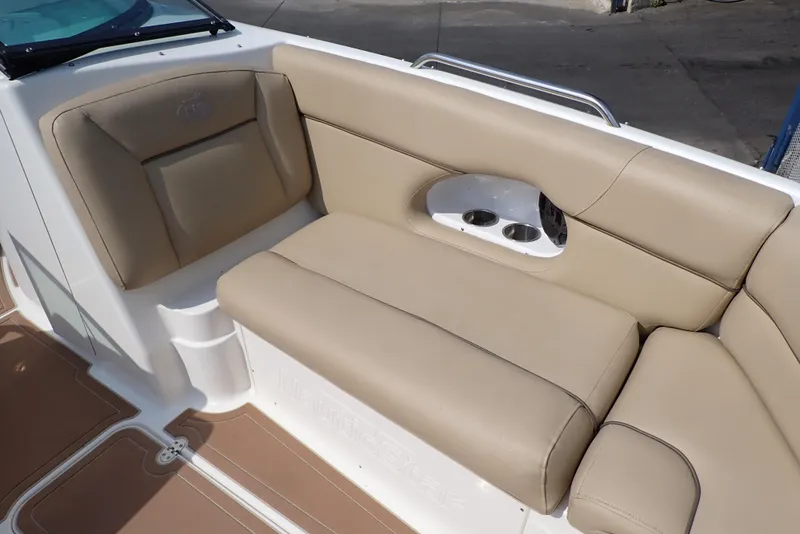 Slide: The Image of 2019 NauticStar 243DC Sport Deck boat with beige seating and cup holders. - 23