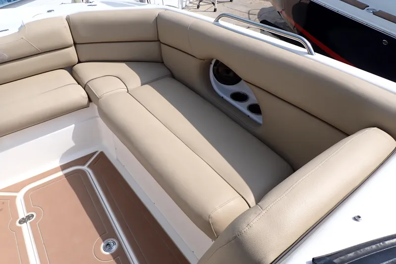 Slide: The Image of 2019 NauticStar 243DC Sport Deck boat with beige seating and cup holders. - 24