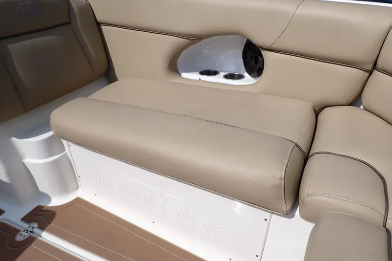 Slide: The Image of 2019 NauticStar 243DC Sport Deck boat interior with beige seating and cup holders. - 29
