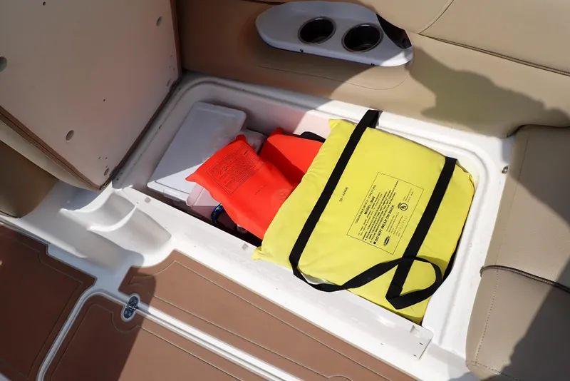 Slide: The Image of Storage compartment in 2019 NauticStar 243DC Sport Deck with life jackets and safety gear. - 30