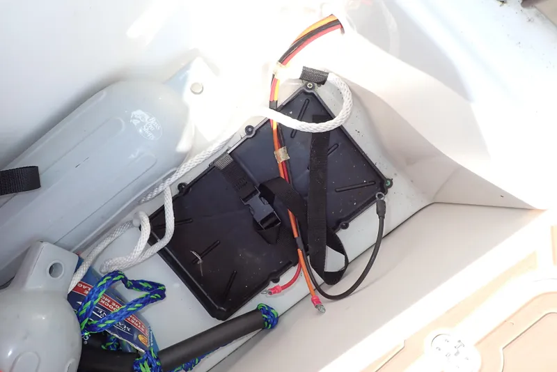 Slide: The Image of 2019 NauticStar 243DC Sport Deck storage compartment with ropes and equipment. - 31
