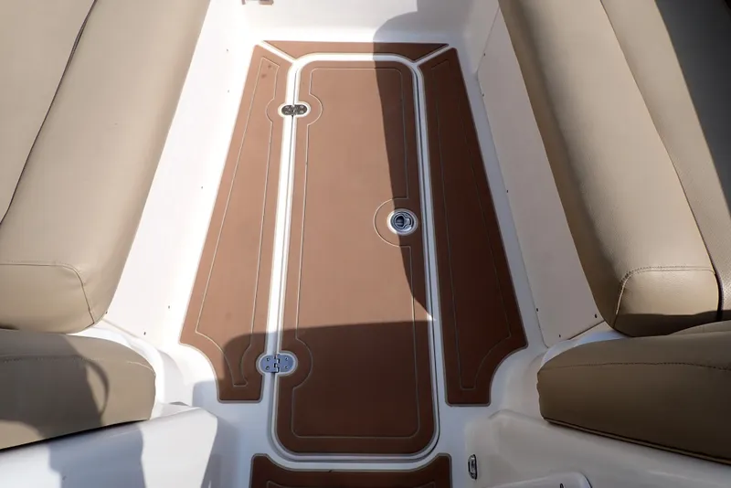 Slide: The Image of 2019 NauticStar 243DC Sport Deck interior with tan seating and brown deck flooring. - 37