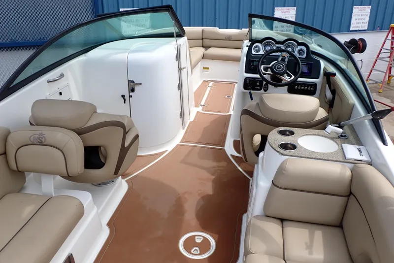 Slide: The Image of 2019 NauticStar 243DC Sport Deck interior with beige seating and modern dashboard. - 4