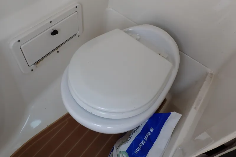 Slide: The Image of 2019 NauticStar 243DC Sport Deck boat toilet area with storage compartment. - 44