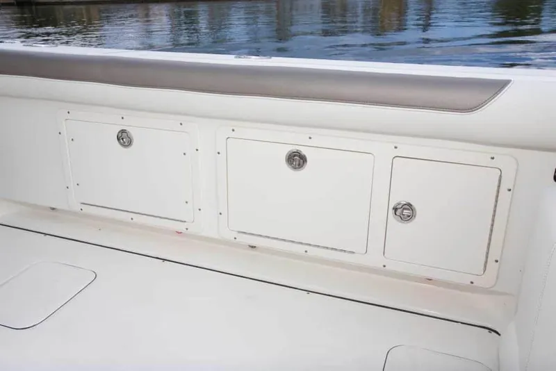 Slide: The Image of 2026 World Cat 295CC boat storage compartments by the water. - 15