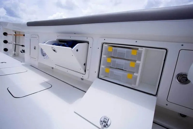Slide: The Image of 2026 World Cat 295CC boat storage compartments and tackle boxes on deck. - 35