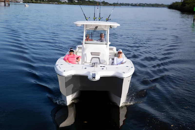 Slide: The Image of 2026 World Cat 295CC boat cruising on calm water with passengers onboard. - 5