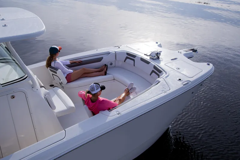 Slide: The Image of 2026 World Cat 295CC boat with two people relaxing on deck in calm waters. - 6