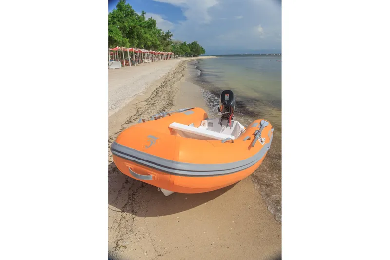 Slide: The Image of Orange Caribe L9 inflatable boat on a sandy beach, 2025 model. - 6
