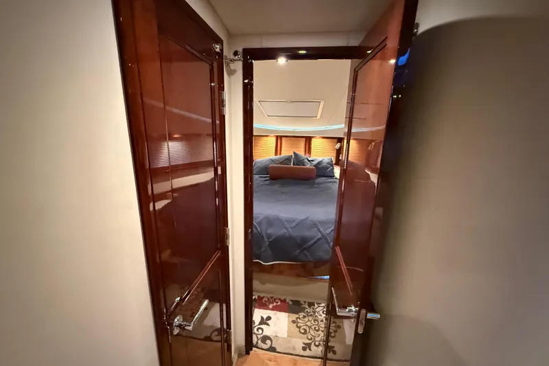 Slide: The Image of Luxurious 2014 Sea Ray 580 Sundancer cabin with elegant wood doors and cozy bedding. - 20