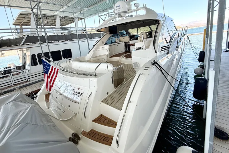 Slide: The Image of Luxurious 2014 Sea Ray 580 Sundancer yacht docked, featuring sleek design and American flag. - 4