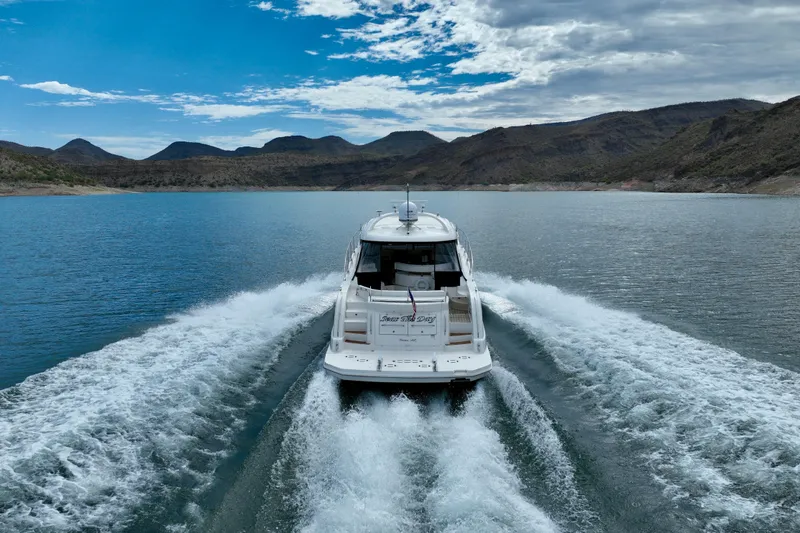 Slide: The Image of 2014 Sea Ray 580 Sundancer cruising on a scenic lake with mountainous backdrop. - 71