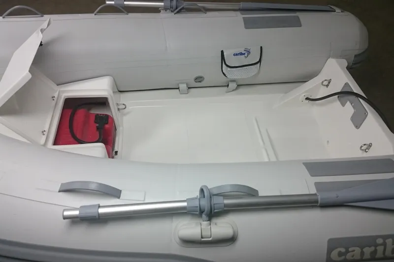 Slide: The Image of Inflatable Caribe C9X boat interior, 2025 model, featuring storage compartment and oar. - 8