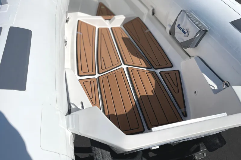 Slide: The Image of Interior of 2025 Caribe L8 boat with teak-style flooring and storage compartment. - 17