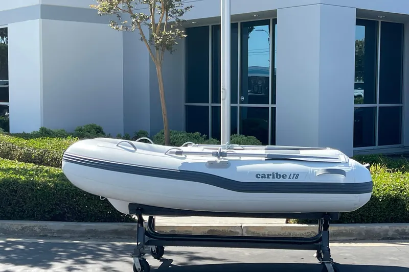 Slide: The Image of 2025 Caribe L8 inflatable boat displayed outdoors on a stand. - 31