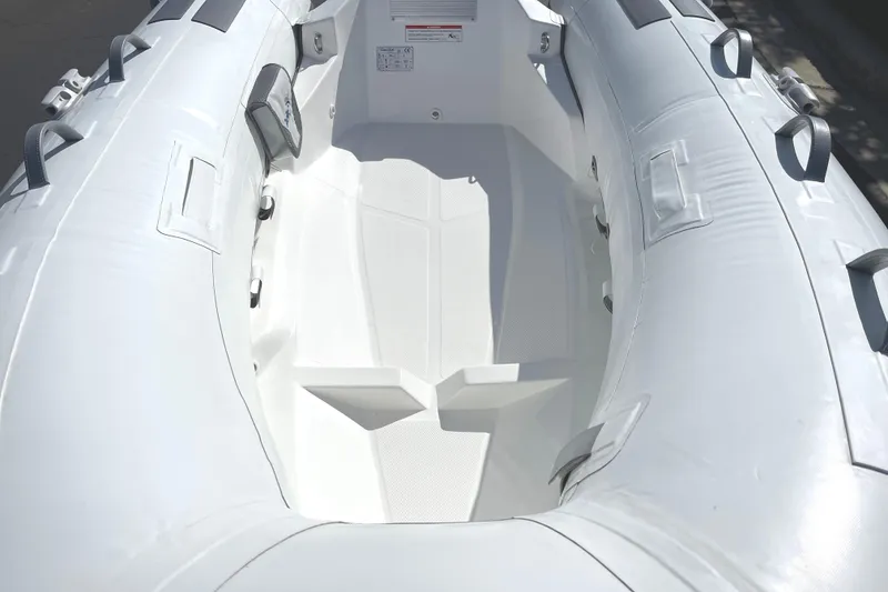 Slide: The Image of Inflatable boat interior, Caribe L8 model, 2025, featuring durable white material and seating. - 9