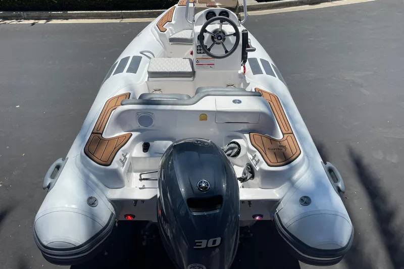 Slide: The Image of 2025 Caribe DL11 inflatable boat with Yamaha engine, featuring sleek design and wood accents. - 30