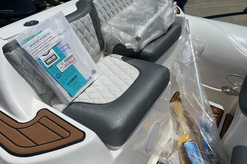 Slide: The Image of 2025 Caribe DL11 boat interior with quilted seats and Yamaha manual on seat. - 35
