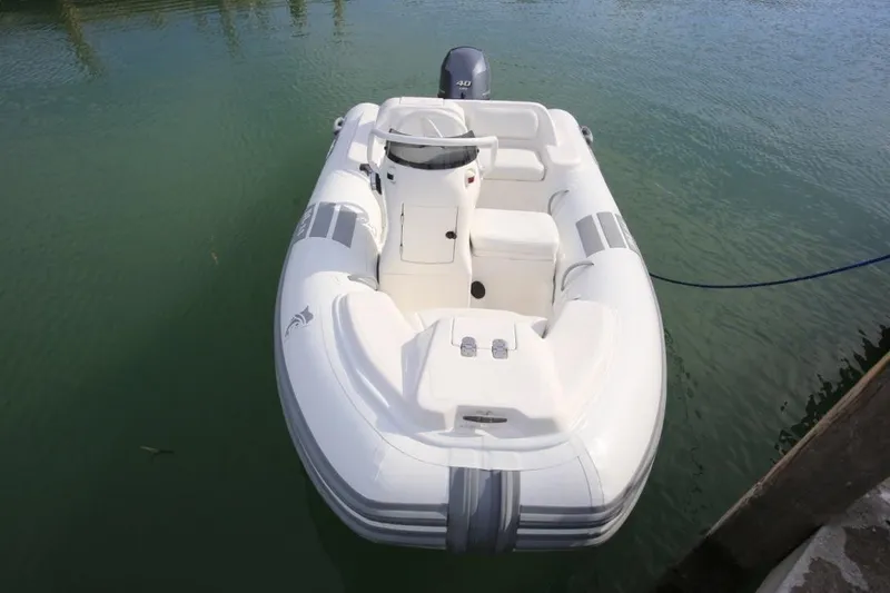 Slide: The Image of 2025 Caribe DL11 inflatable boat docked on calm water. - 44