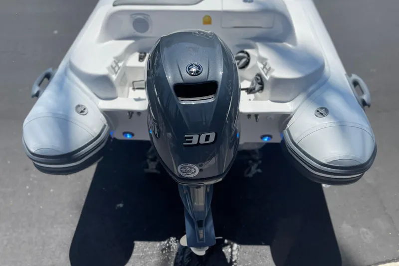 Slide: The Image of 2025 Caribe DL11 boat with a 30 HP outboard motor, rear view. - 9