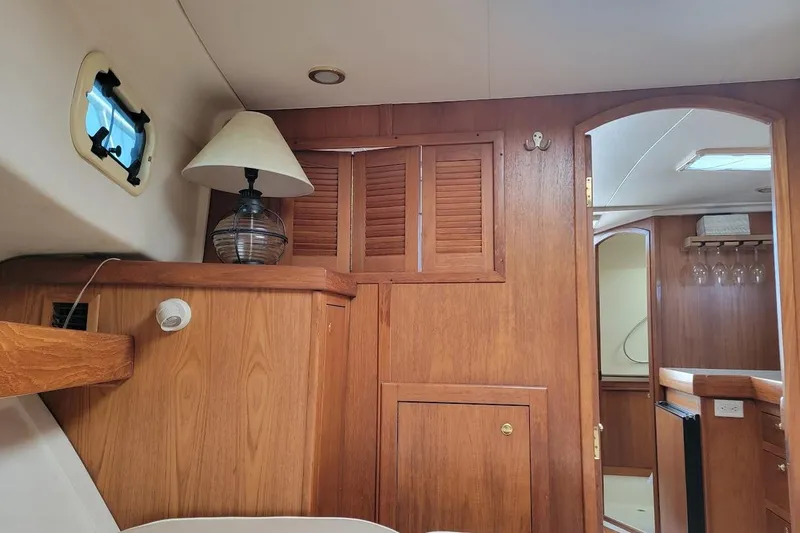 Slide: The Image of Interior of 2000 Mainship 34 PILOT with wooden cabinetry and nautical decor. - 14
