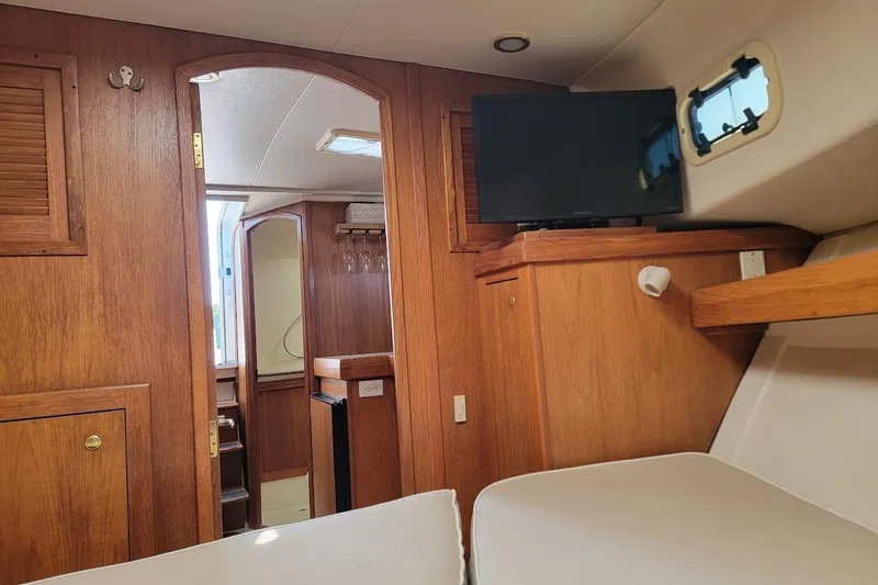 Slide: The Image of Interior of 2000 Mainship 34 PILOT boat with wood paneling and mounted TV. - 15