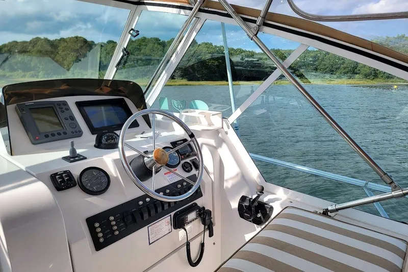 Slide: The Image of 2000 Mainship 34 PILOT boat cockpit with steering wheel and navigation equipment. - 2