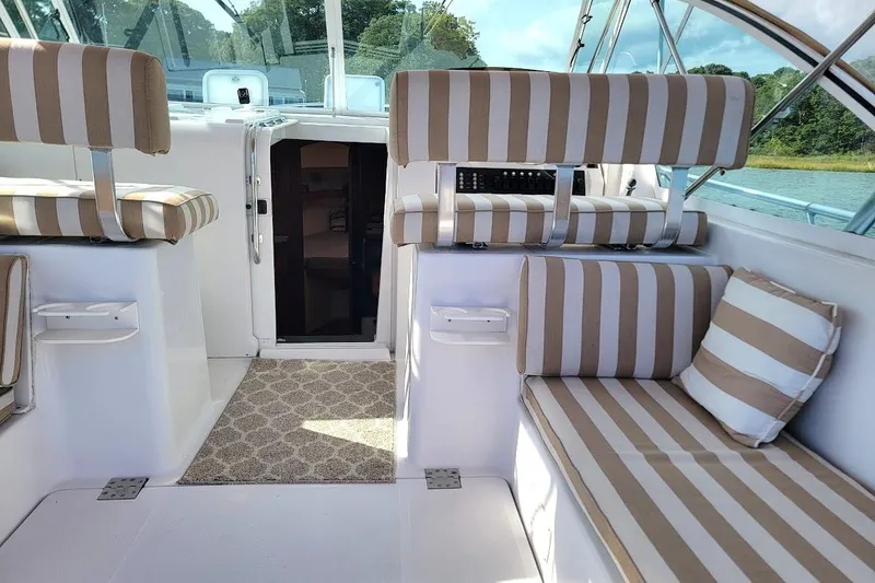 Slide: The Image of Interior of 2000 Mainship 34 PILOT boat with striped seating and open cabin door. - 20