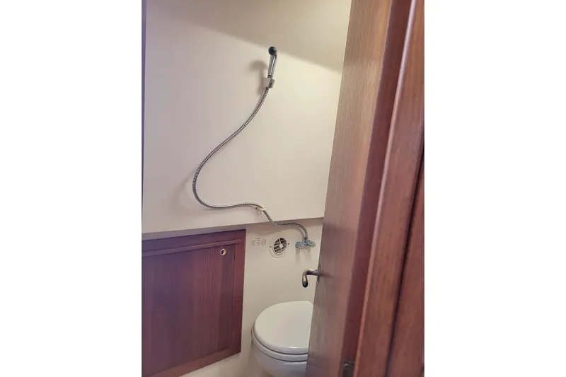 Slide: The Image of 2000 Mainship 34 PILOT boat bathroom with showerhead and wooden cabinet. - 28