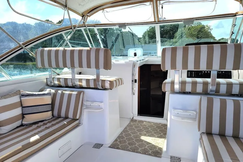 Slide: The Image of Interior of 2000 Mainship 34 PILOT with striped seating and open cabin door. - 4