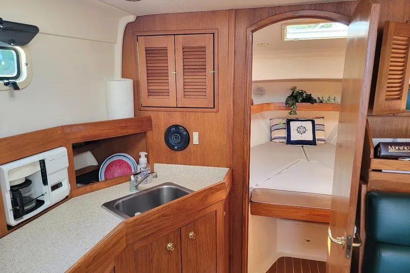 Slide: The Image of Cozy interior of 2000 Mainship 34 PILOT with kitchenette and sleeping area. - 5