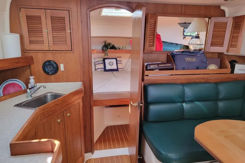 Slide: The Image of Interior of 2000 Mainship 34 PILOT yacht with cozy seating and compact kitchen area. - 6