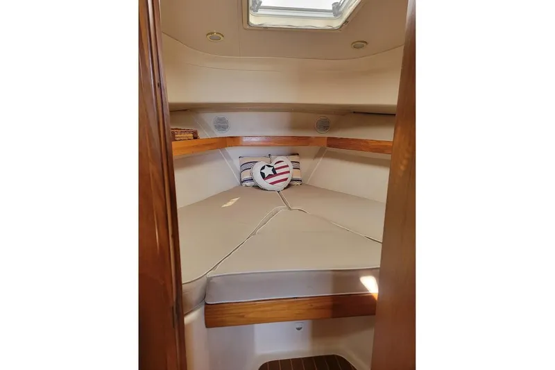 Slide: The Image of 2000 Mainship 34 PILOT cabin interior with cozy bed and nautical-themed decor. - 9