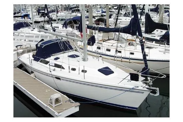 The Image of 2005 Catalina 320 sailboat docked in a marina, surrounded by other boats. - 1