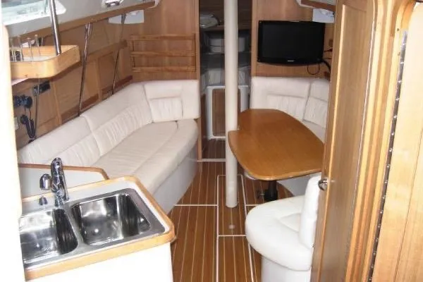 Slide: The Image of Interior of a 2005 Catalina 320 sailboat with wood finish and white seating. - 3