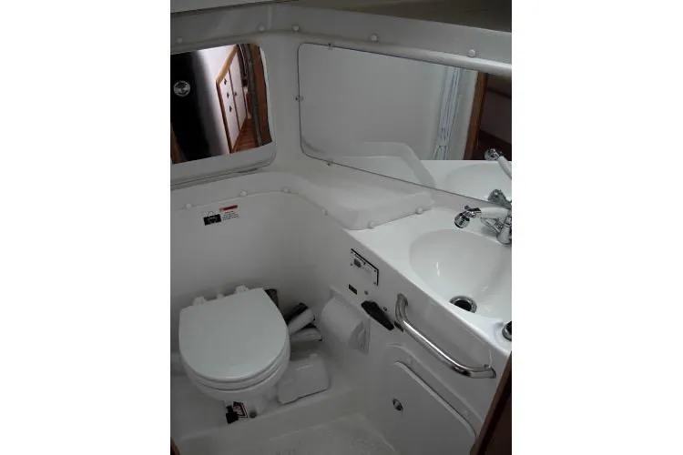 Slide: The Image of 2005 Catalina 320 yacht bathroom with toilet, sink, and mirror. - 9