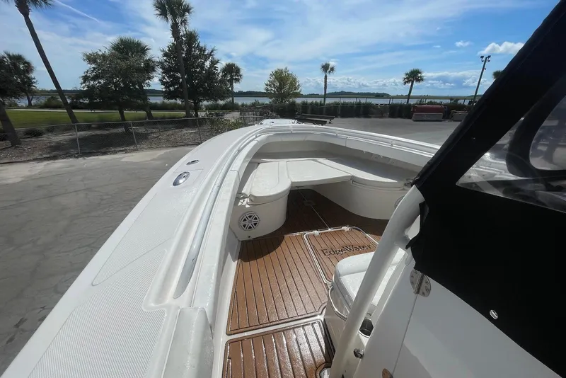 Slide: The Image of 2008 Edgewater 370CC boat with spacious deck and seating, under a clear blue sky. - 7
