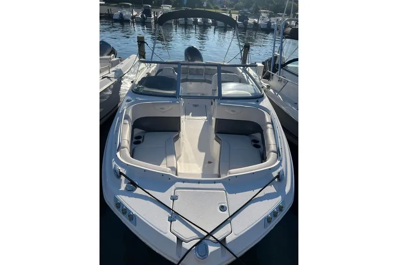 Slide: The Image of 2018 Chaparral 230 Suncoast boat docked in a marina, surrounded by other vessels. - 2
