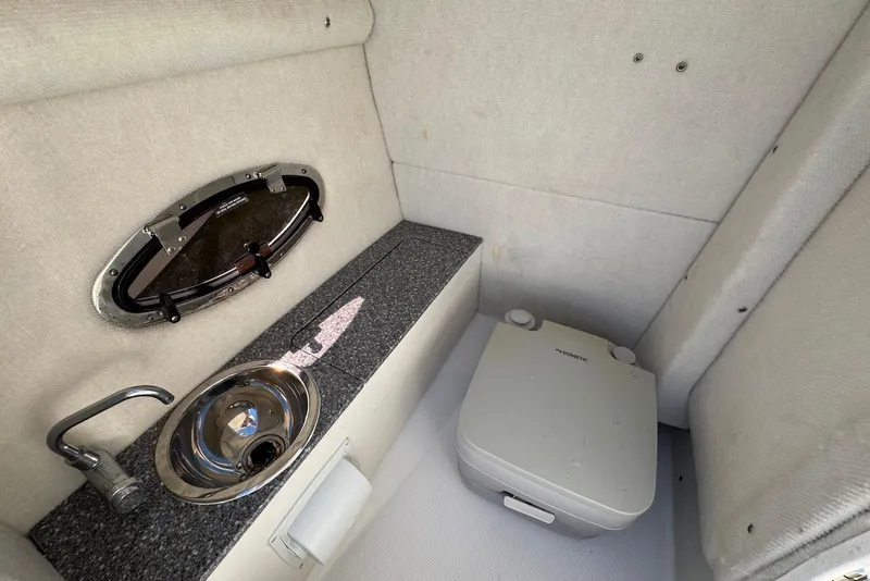 Slide: The Image of 2018 Chaparral 230 Suncoast boat interior with sink and portable toilet. - 20