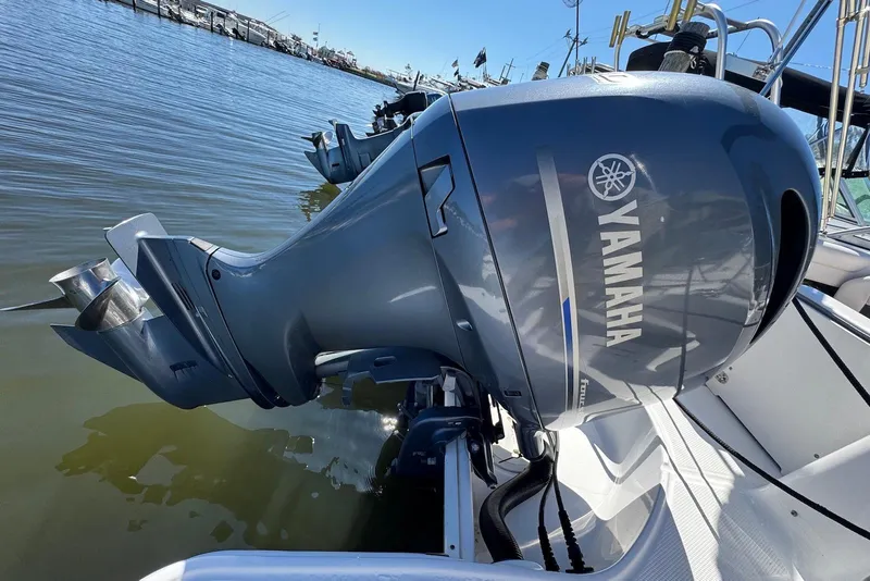 Slide: The Image of Yamaha outboard motor on 2018 Chaparral 230 Suncoast boat, docked by the water. - 23