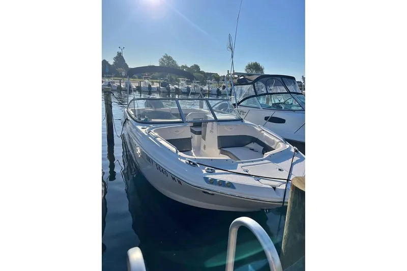 Slide: The Image of 2018 Chaparral 230 Suncoast boat docked at marina, surrounded by other vessels. - 3