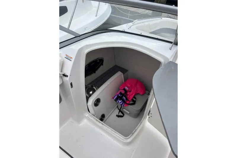 Slide: The Image of 2018 Chaparral 230 Suncoast boat interior with cushioned seating and sleek design. - 5