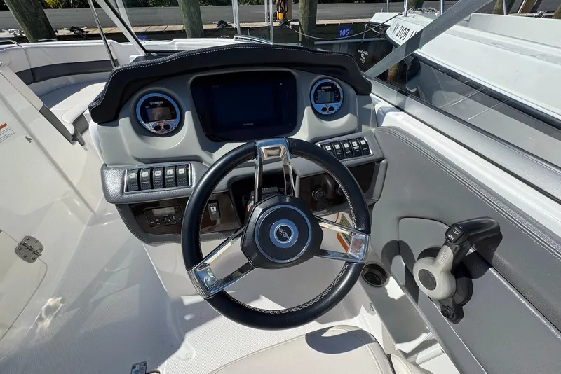 Slide: The Image of 2018 Chaparral 230 Suncoast boat dashboard with steering wheel and control panel. - 9