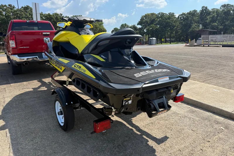Slide: The Image of 2016 Sea-Doo GTR 215 jet ski on trailer, parked near red truck. - 45